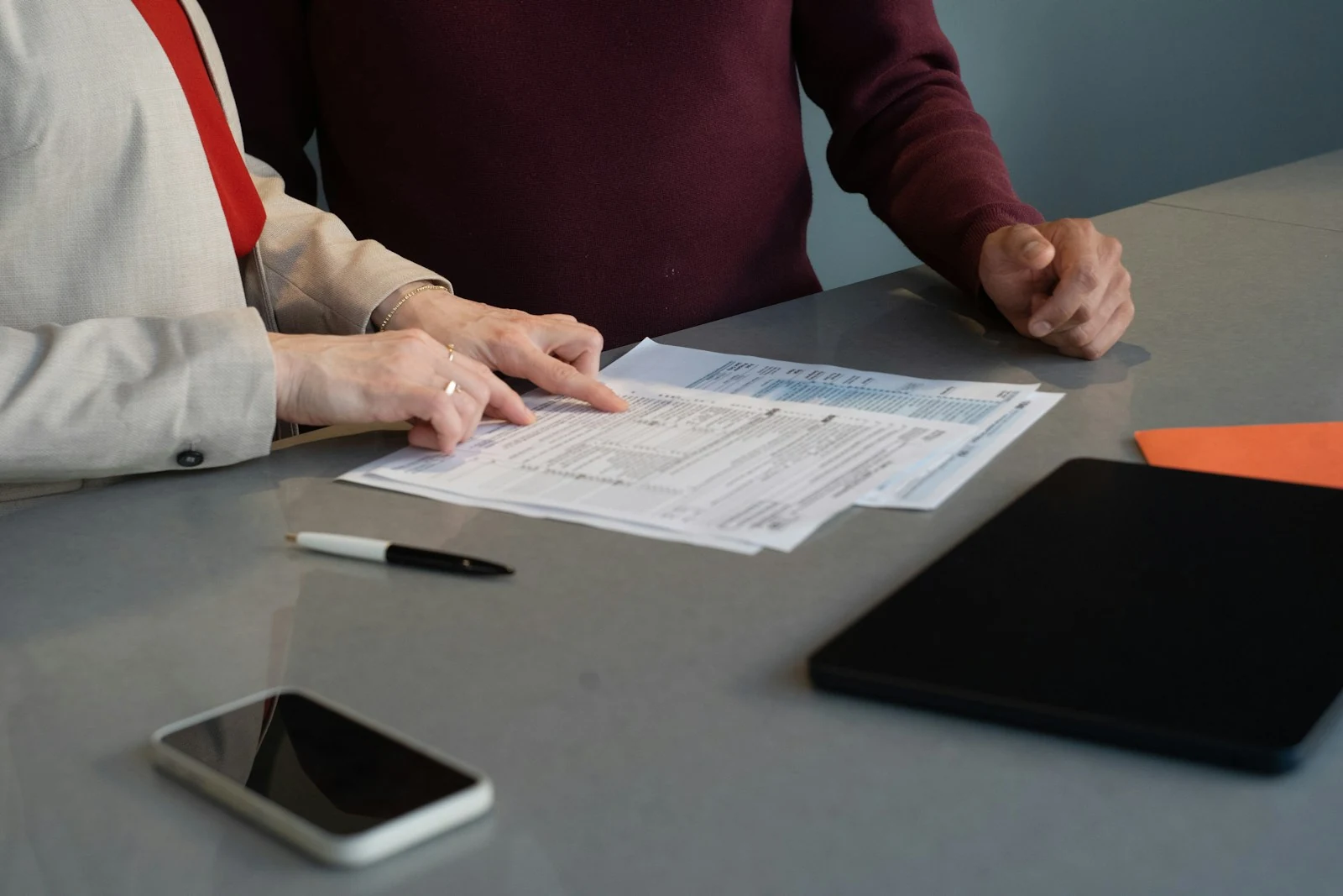 People completing important documents together at a table